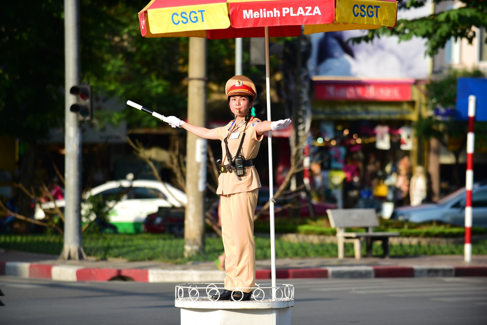 Thượng úy Nguyễn Thị Thu Giang – Đội CSGT số 1 – Phòng CSGT đường sắt – đường bộ Công an Hà Nội ‘gồng mình’ điều tiết giao thông dưới cái nắng bỏng rát. (Ảnh: Minh Sơn/Vietnam+)