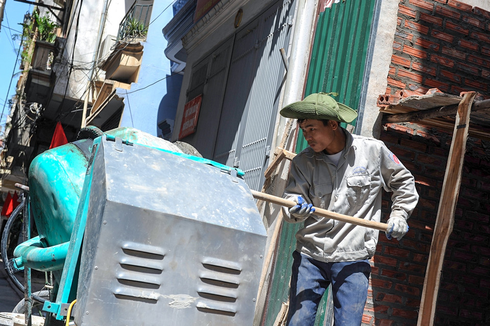 Một công nhân xây dựng chia sẻ, dù giữa trưa nhưng anh vẫn không được nghỉ vì phải làm đúng tiến độ công trình mà chủ nhà yêu cầu. (Ảnh: Minh Sơn/Vietnam+)