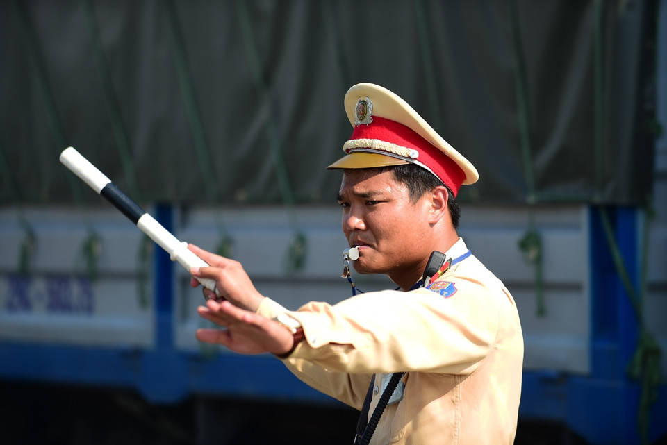 Những chiến sỹ cảnh sát giao thông Hà Nội mướt mải mồ hôi để phân luồng đường. Những ngày nắng nóng, nhiều phương tiện tham gia giao thông rất tùy tiện. (Ảnh: Minh Sơn/Vietnam+)