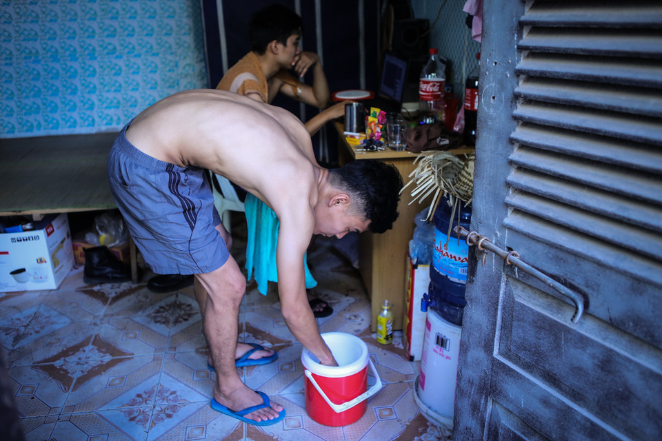 Các bạn sinh viên rủ nhau mua đá viên tích trữ trong bình, thi thoảng lấy vài viên dùng khăn ủ cho mát. (Ảnh: Minh Sơn/Vietnam+)