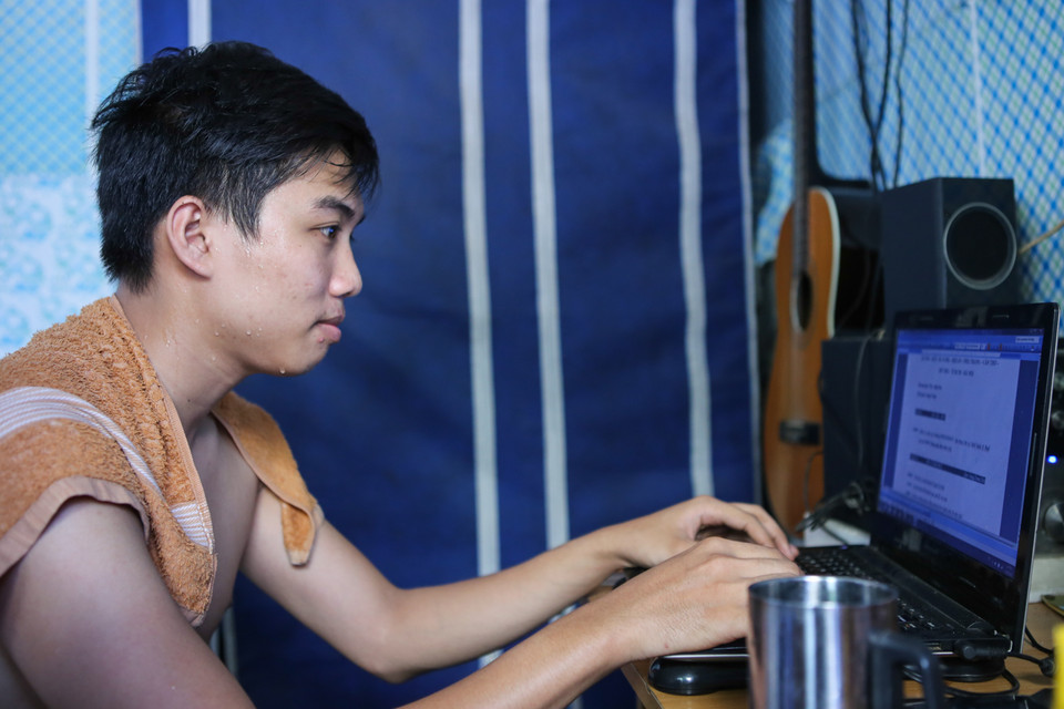 Lê Quốc Sơn (quê Quảng Ninh) bạn cùng phòng trọ với Hoàng vã mồ hôi vì nóng, em than thở: ‘Ở khu trọ này đến tận khuya phòng vẫn hầm hập vì mái tôn giữ nhiệt, đêm đến em bật 3 cái quạt vẫn thế’. (Ảnh: Minh Sơn/Vietnam+)