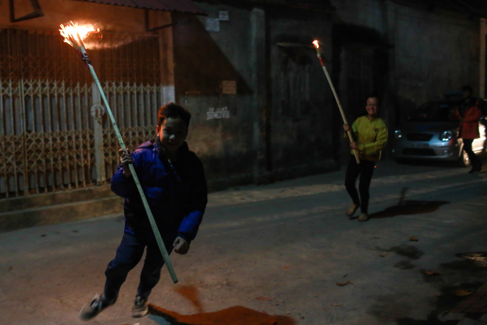 Ai lấy được lửa sẽ chạy nhanh về nhà, vừa chạy vừa giữ không cho lửa tắt. (Ảnh: Minh Sơn/Vietnam+)