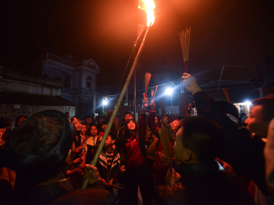 Đúng 21 giờ, chủ tế của lễ, ông Lê Như Khuê là người duy nhất được bước vào bên trong hậu cung để lấy lửa và mang ra trong sự chờ đợi hào hứng của dân làng. (Ảnh: Minh Sơn/Vietnam+) 