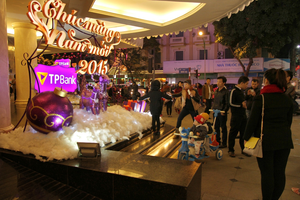 Tại sảnh và đường chính, người dân nô nức chụp ảnh cùng cây thông, xe tuần lộc. (Ảnh: PV/Vietnam+)