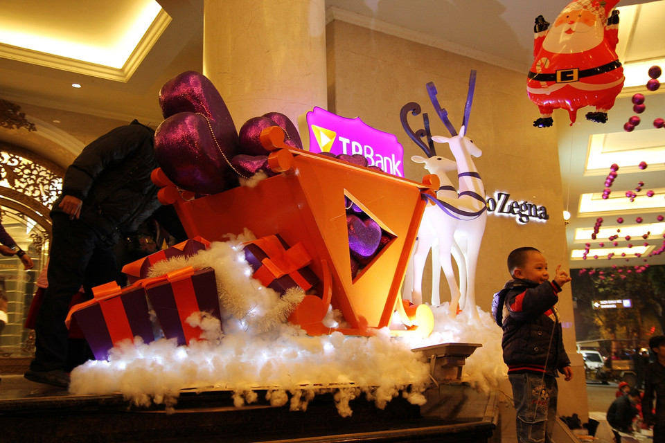 Nhiều trẻ em cũng được bố mẹ đưa đi và tìm hiểu các câu chuyện về Giáng sinh. (Ảnh: PV/Vietnam+)