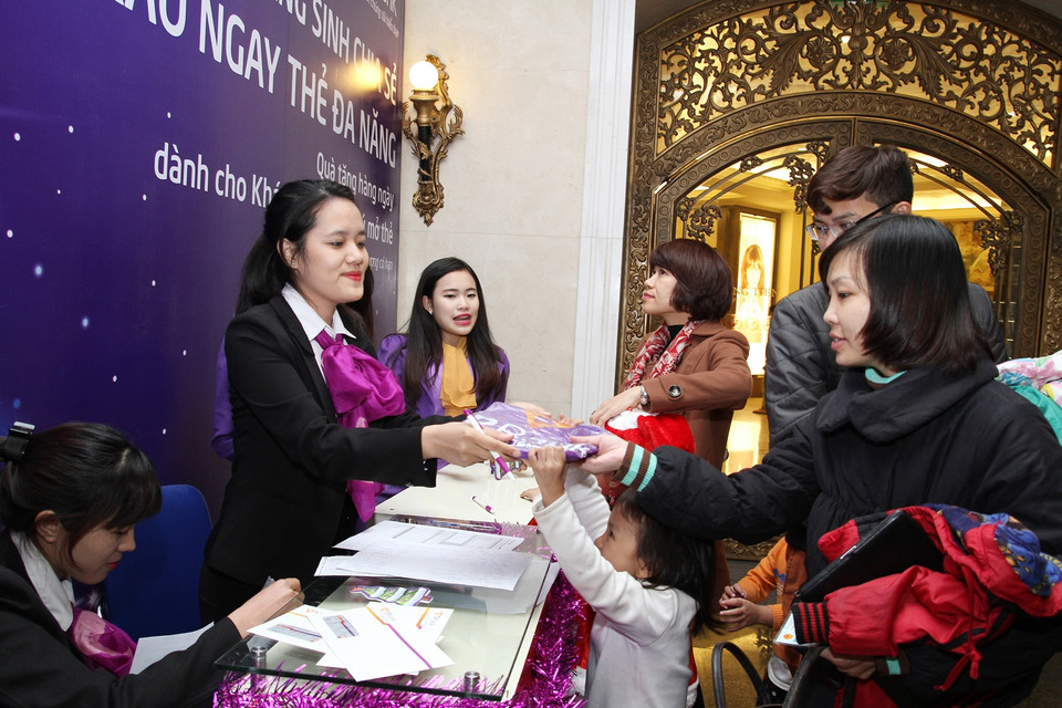 Một người dân đang tìm hiểu cách mở thẻ của TPBank – đơn vị đăng cai trang hoàng khu vực Tràng Tiền Plaza năm nay. (Ảnh: PV/Vietnam+)