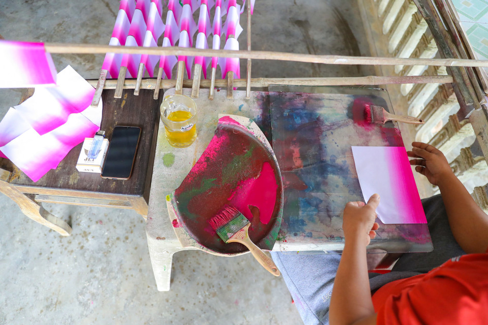 Để làm được một cánh hoa thì đòi hỏi các nghệ nhân phải có đôi bàn tay khéo léo và tỉ mỉ, các công đoạn để làm được một cánh hoa gồm có: tre được vót nhỏ và phơi khô; giấy được nhuộm màu; hoa và nhụy được cắt tỉa một cách tỉ mỉ để khi lấy hồ dán sẽ tạo được một cành hoa hài hòa về màu sắc lẫn bố cục. (Ảnh: PV/Vietnam+)