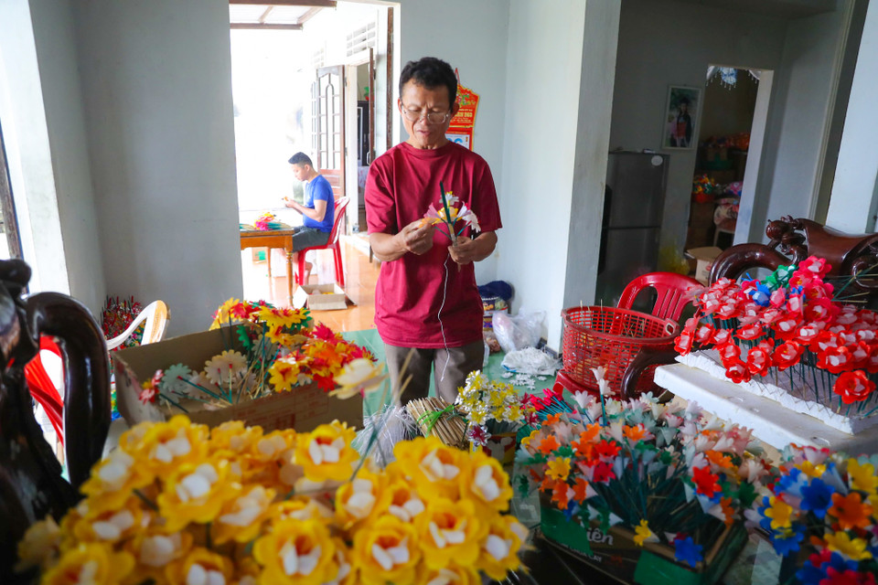 Cái khó của người làm hoa giấy là phải làm sao giống như hoa thật, cũng có cành lá, búp, nhị, mềm mại. (Ảnh: PV/Vietnam+)