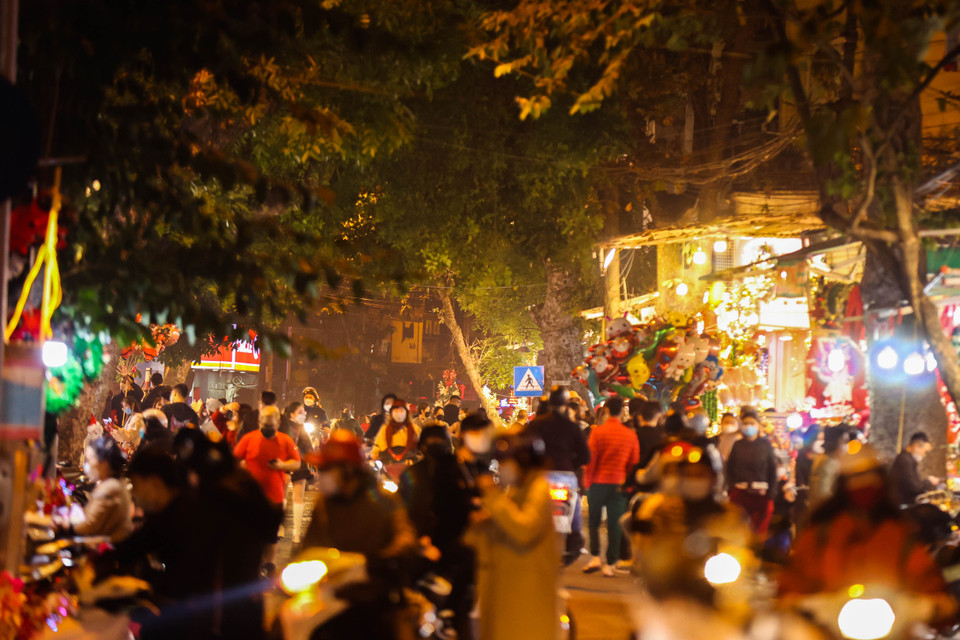 Dòng người đổ về kín cả con phố lung linh dưới ánh đèn và rực rỡ sắc màu của các cửa hàng bán đồ trang trí. (Ảnh: Hoài Nam/Vietnam+)