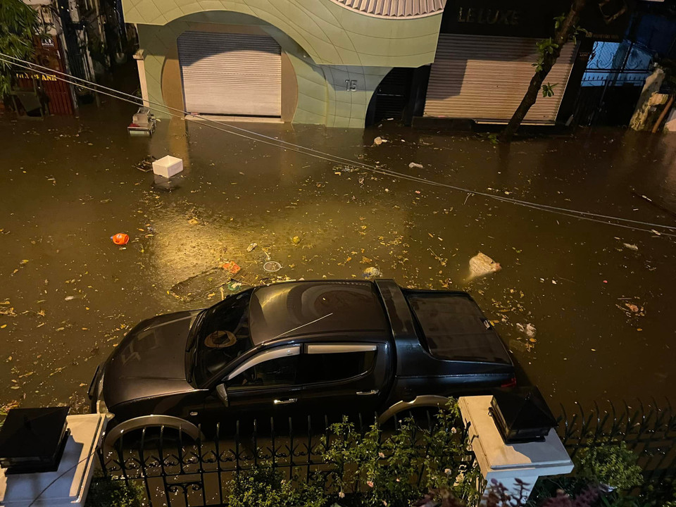 Chiếc ôtô này đang 'bồng bềnh' cùng rác thải tại phố Nguyễn Gia Thiều. (Ảnh: PV/Vietnam+)