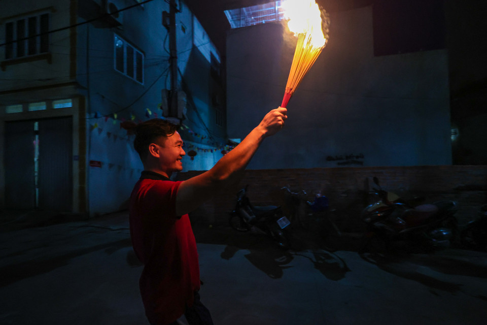 Người dân An Định cho hay, "lấy đỏ" về cho gia đình phải lấy thật nhanh, ngọn đuốc hay nén hương mang về nhà càng cháy nhiều thì lộc càng lớn, gia đình càng may mắn, làm ăn càng phát đạt. (Ảnh: Minh Sơn/Vietnam+)