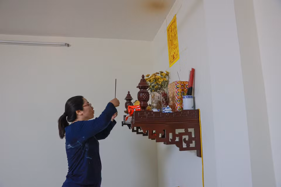 Chị Quỳnh, một người dân làng An Định chia sẻ: "Năm nào mình cũng tham dự để lấy lửa về thắp hương bàn thờ gia tiên để cầu mong một năm mới con cái học hành chăm ngoan, gia đình làm ăn thuận buồm xuôi gió." (Ảnh: Minh Sơn/Vietnam+)
