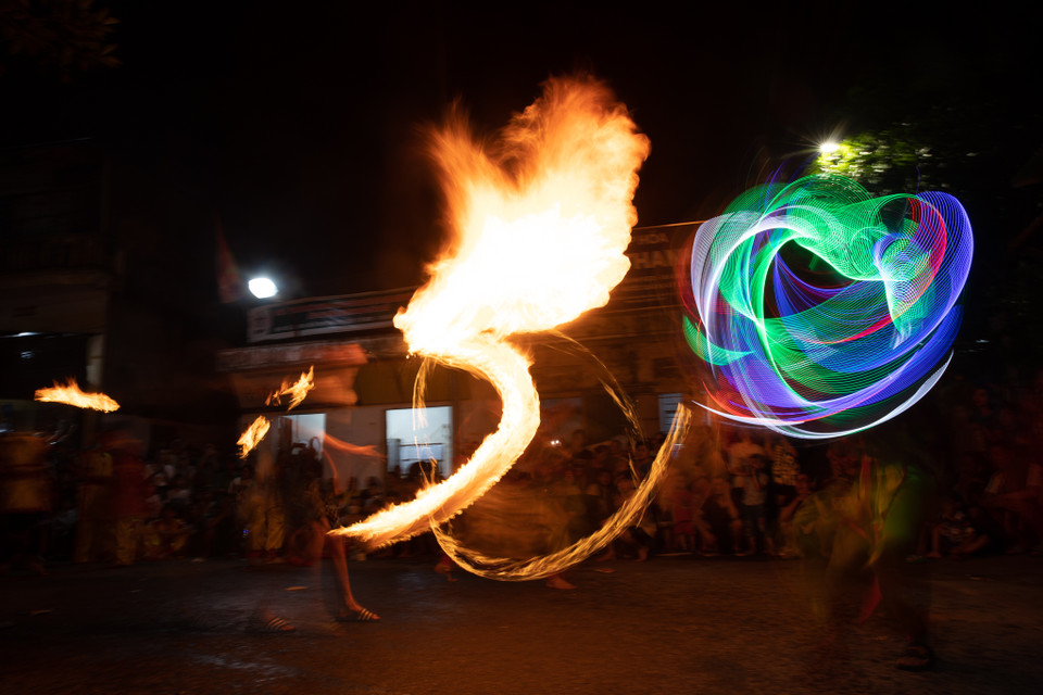 Những thành viên bên ngoài sẽ cầm đuốc biểu diễn giống như đang 'đánh nhau' với lân theo nhịp trống, tạo nên hình ảnh rất hấp dẫn, mang đậm văn hoá của ngày Tết Trung thu. (Ảnh: Minh Sơn/Vietnam+)