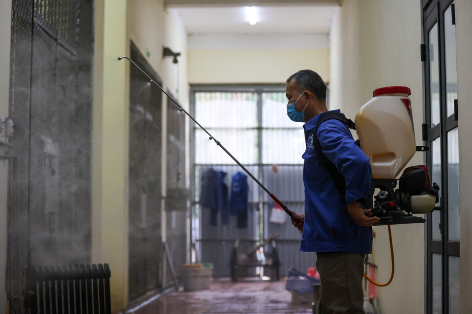 Thời gian dịch COVID-19 kéo dài, anh Phúc cùng đồng nghiệp phải liên tục vệ sinh chuồng trại, phun khử khuẩn đảm bảo sức khỏe cho thú dữ tại đây. (Ảnh: Minh Sơn/Vietnam+)