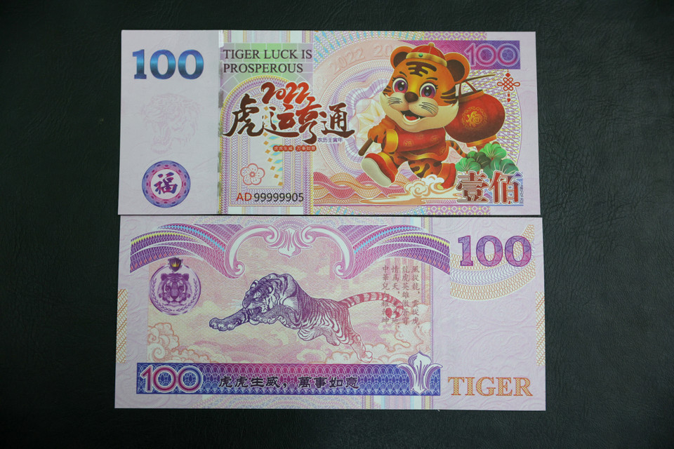 Tờ 100 có in hình con hổ là loại tiền lưu niệm của Đài Loan in ấn để làm tiền lì xì tết 2022 Nhâm Dần. Với lợi thế là giá rẻ nên đây là mẫu tiền lì xì được nhiều người chọn mua. (Ảnh: Minh Sơn/Vietnam+)