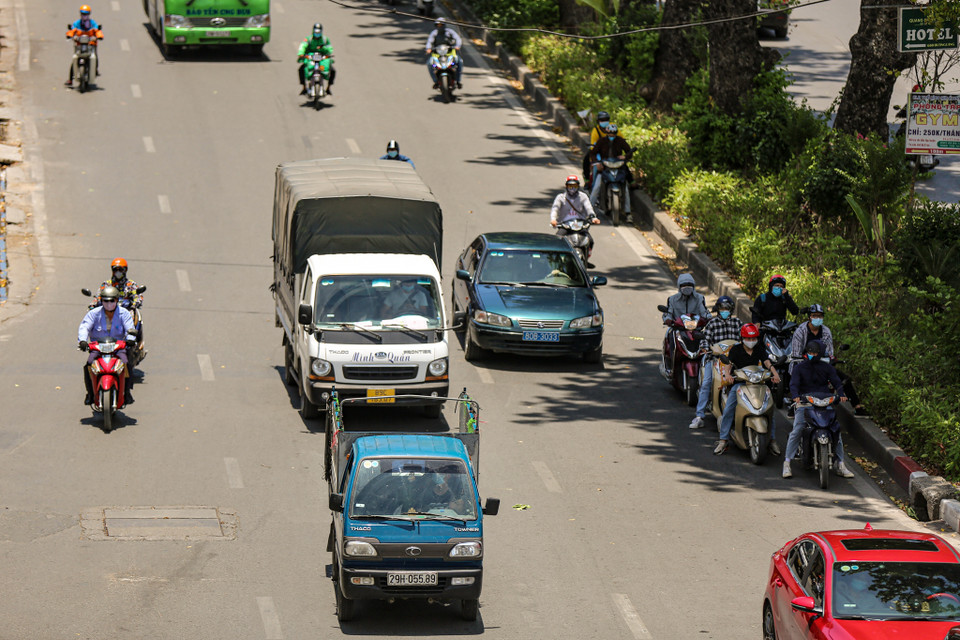 Nhiều phương tiện lựa chọn dừng đèn đỏ dưới bóng cây râm mát. (Ảnh: PV/Vietnam+)