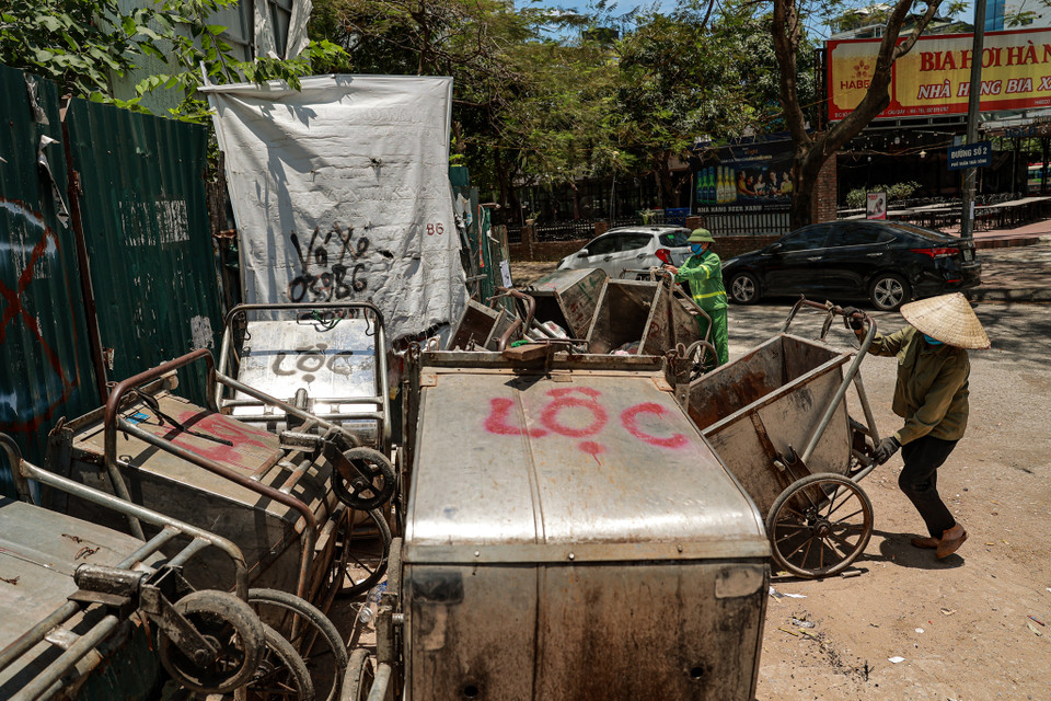 Công nhân vệ sinh môi trường vẫn tiếp tục làm việc dù nhiệt độ vào buổi trưa tăng cao. (Ảnh: PV/Vietnam+)