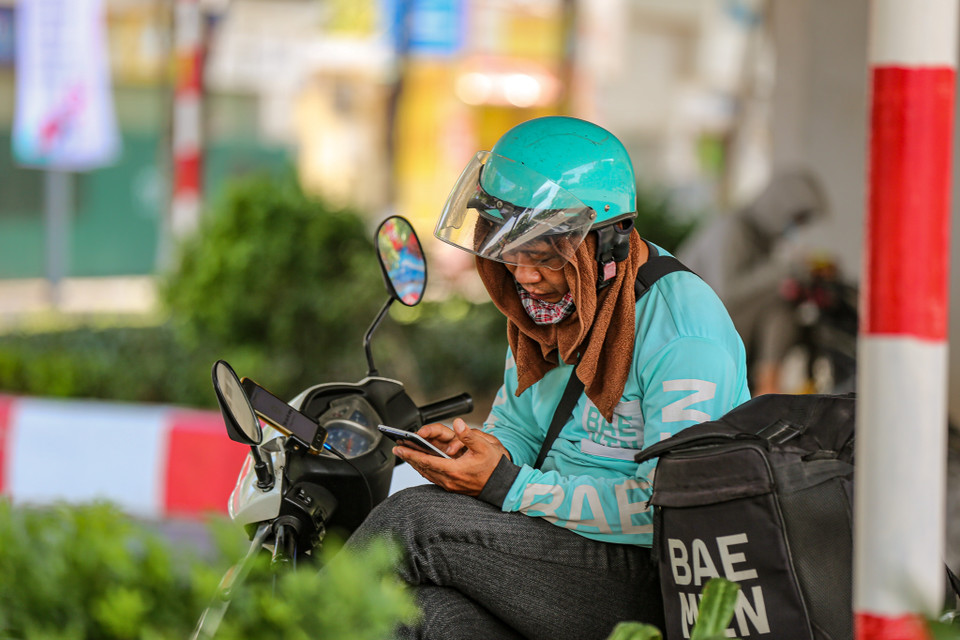 Trên đường phố, nhiều người tận dụng bóng mát dưới những gốc cây, gầm cầu để nghỉ ngơi, tránh nắng. (Ảnh: PV/Vietnam+)