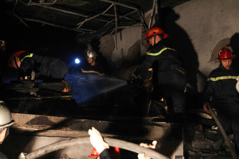 Mặc dù đám cháy cơ bản được khống chế nhưng vẫn còn rất nhiều lửa nhỏ cháy âm ỉ nên lực lượng phòng cháy chữa cháy phải bơm nước liên tục. (Ảnh: Minh Sơn/Vietnam+)