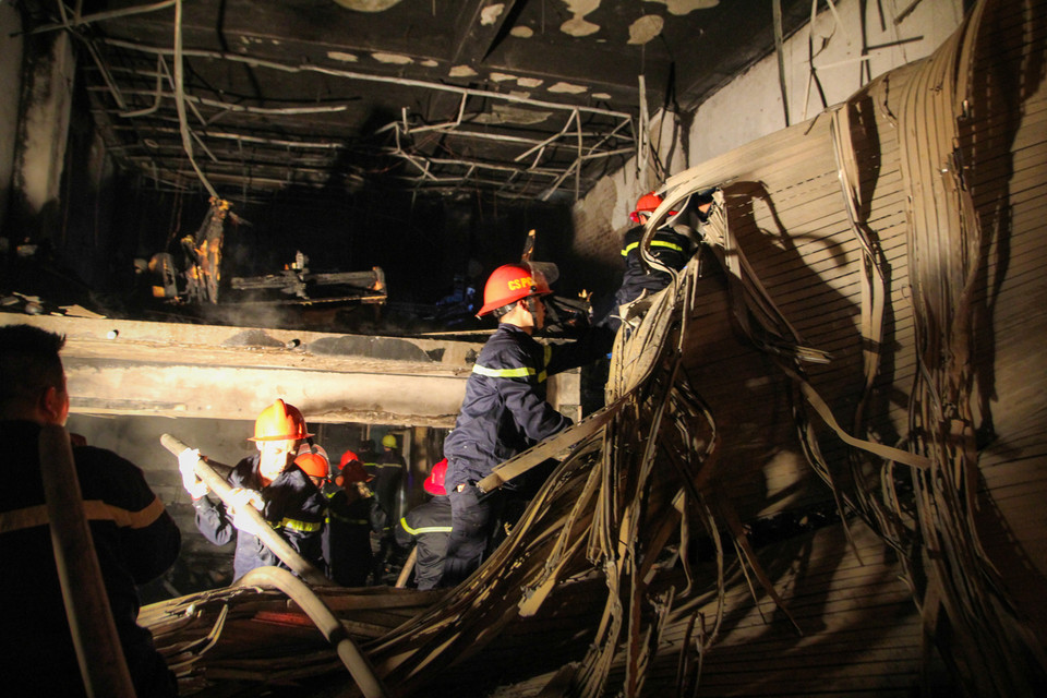 Nhiệt độ từ đám cháy khiến cho cả cánh cửa cuốn chắc chắn cũng phải sụp đổ. (Ảnh: Minh Sơn/Vietnam+)