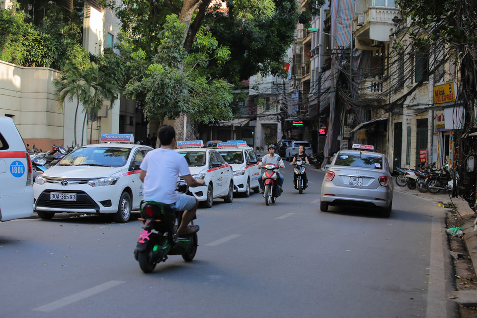 Tại đường Phó Đức Chính (Tây Hồ, Hà Nội) taxi ‘nuốt’ luôn một bên đường vốn đã chật hẹp để chờ đón trả khách. (Ảnh: Minh Sơn/Vietnam+)
