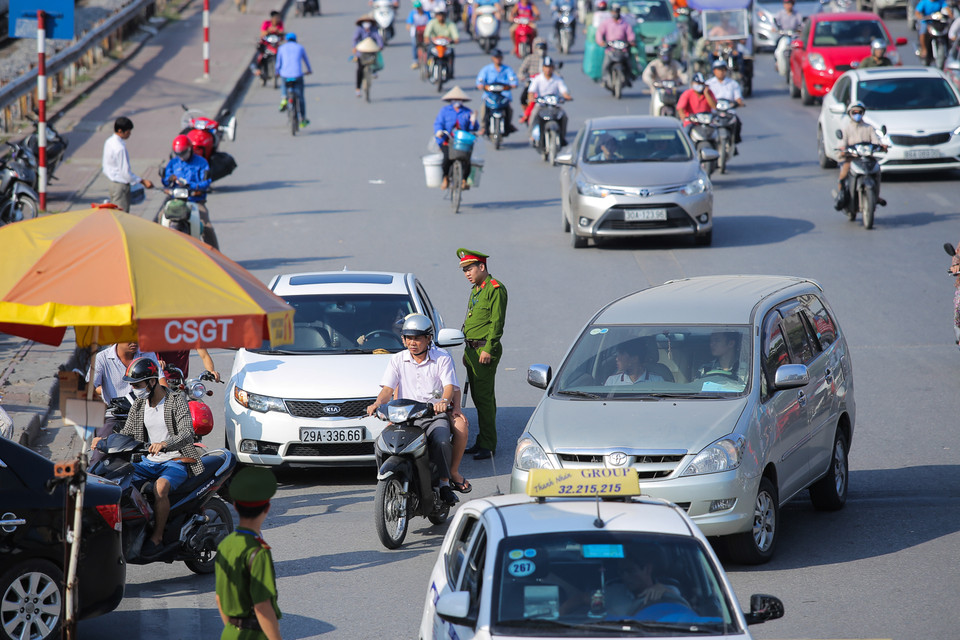 Bất lực trong việc vừa đuổi xe taxi đi, xe ô tô cá nhân lại dừng đỗ trước cổng coi như không biết gì. (Ảnh: Minh Sơn/Vietnam+)
