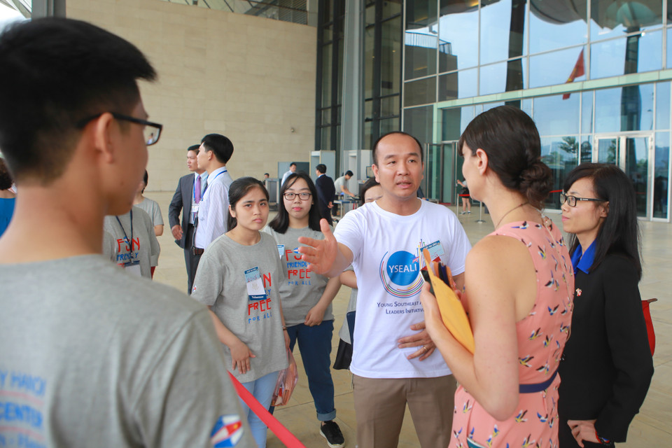 Các tình nguyện viên của chương trình đang giúp đỡ khách mời làm thủ tục kiểm tra an ninh trước khi vào hội trường lớn. (Ảnh: PV/Vietnam+)