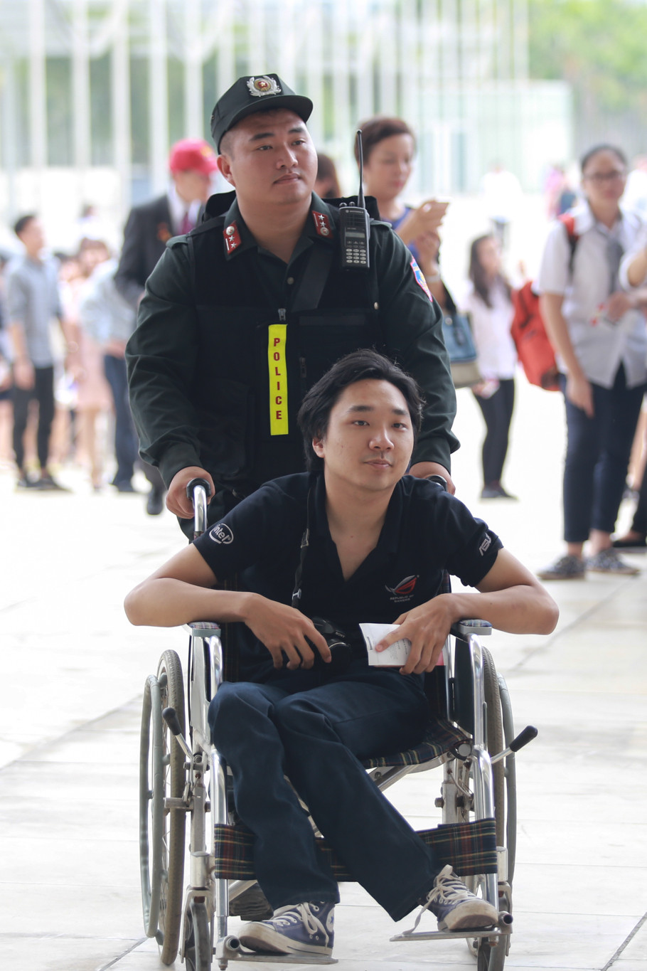 Một bạn trẻ được lực lượng bảo an hỗ trợ đi vào sảnh chính. (Ảnh: PV/Vietnam+)