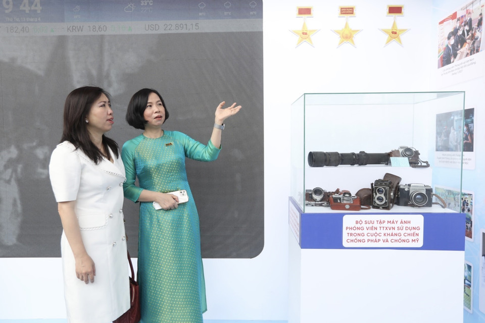 Tổng giám đốc Vũ Việt Trang (phải) giới thiệu với đại biểu về gian trưng bày của TTXVN tại Hội báo. (Ảnh: TTXVN)