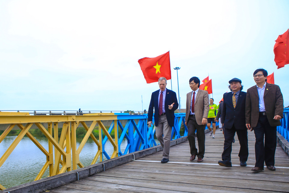 Đại sứ Mỹ bước qua vạch kẻ ngang. Trước đây là ranh giới phân chia 2 nửa cây cầu Hiền Lương, cũng là chia nửa đất nước. Ngài Đại sứ cũng khẳng định, nếu chúng ta muốn có một tương lai tốt đẹp, chúng ta nên thành thật với quá khứ. (Ảnh: Minh Sơn/Vietnam+)