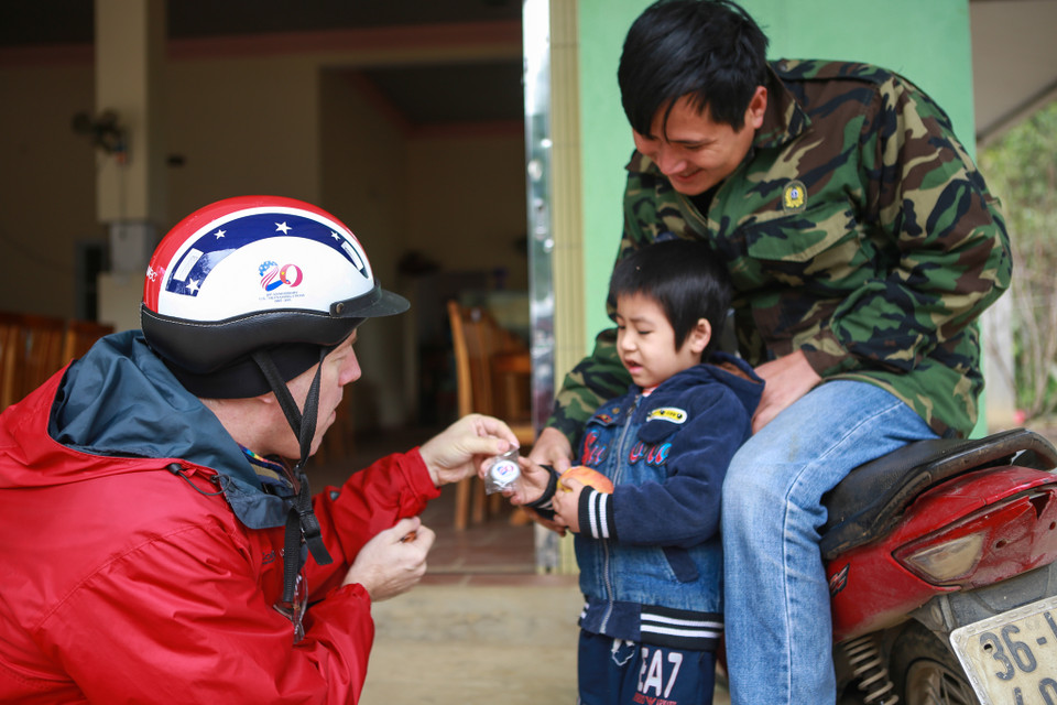 Ngài Ted Osius trao chiếc huy hiệu in hình kỷ niệm 20 năm mối quan hệ ngoại giao Việt Nam – Hoa Kỳ cho một em bé. (Ảnh: Minh Sơn/Vietnam+)
