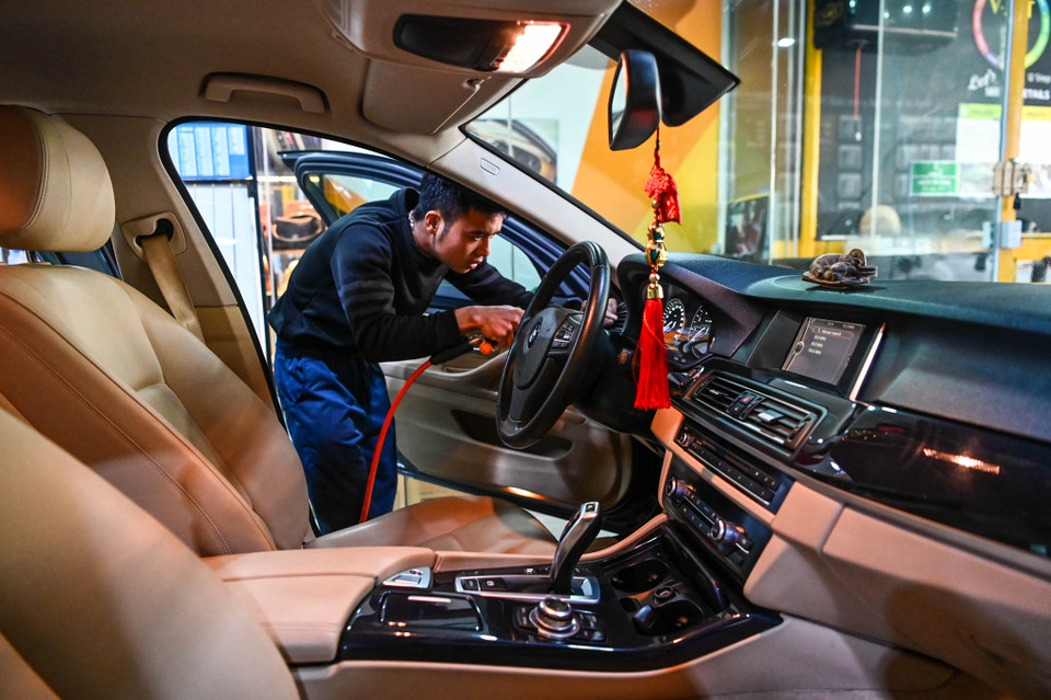 Nhân viên tại một gara ôtô tiết lộ, một ngày anh và các đồng nghiệp có thể rửa đến 100 lượt xe ôtô dịp giáp Tết. (Ảnh: Minh Sơn/Vietnam+)