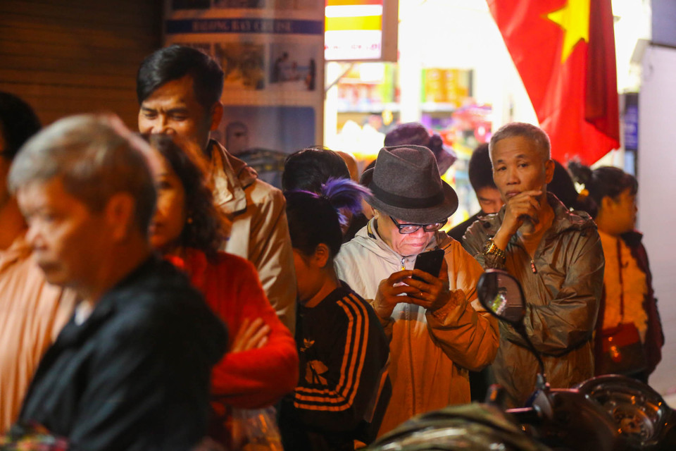 Từ sáng sớm ngày 30 Tết, rất đông người dân đã đứng chờ tới lượt mua bánh chưng. (Ảnh: Minh Sơn/Vietnam+)