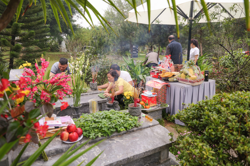 Sau khi lau dọn xong, mọi người sẽ lần lượt thắp hương, đặt lễ để cúng mộ. (Ảnh: Quỳnh Anh/Vietnam+)