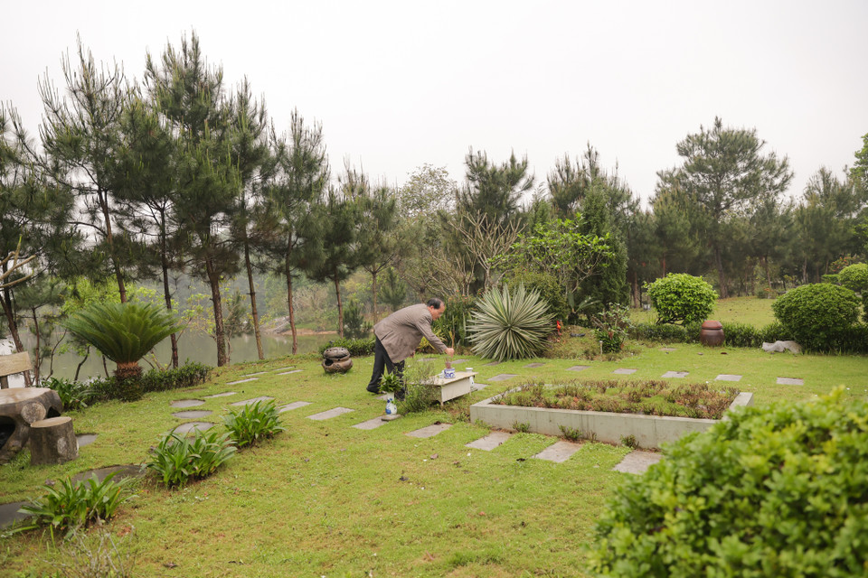 Không chỉ chăm sóc, thắp hương cho phần mộ gia tiên của mình, gia đình ông Thìn cũng tranh thủ thắp hương cho những phần mộ bên cạnh để thể hiện lòng biết ơn, thương cảm và sẻ chia. (Ảnh: Quỳnh Anh/Vietnam+)