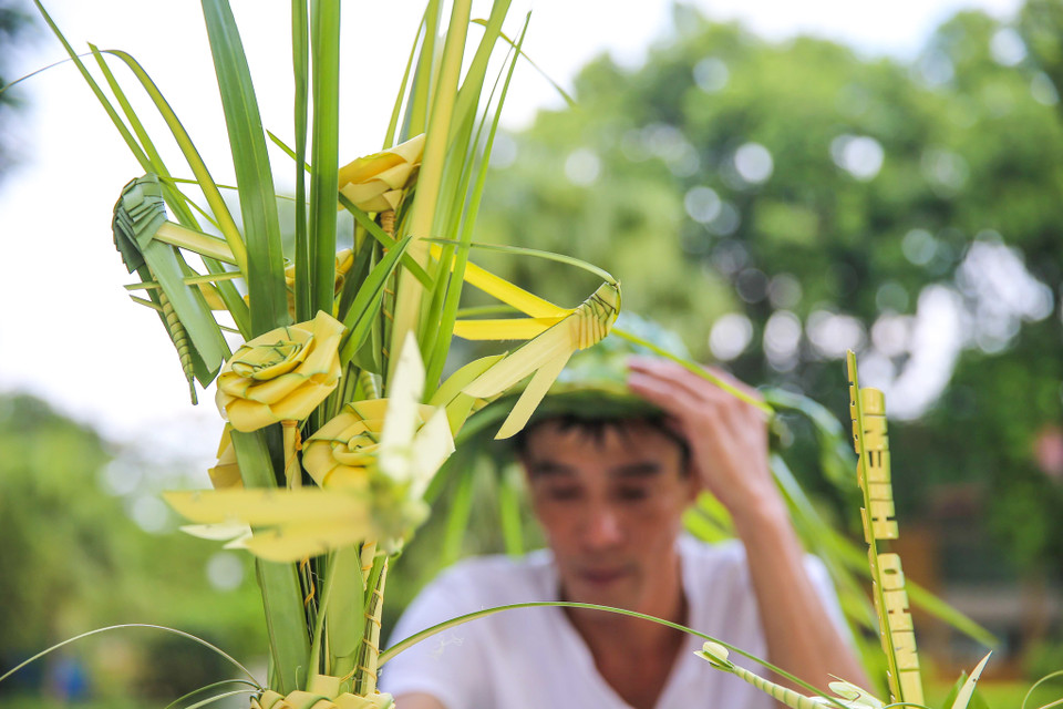 Giá bán mỗi con giống làm từ lá dừa 15.000 đồng/con, hoa hồng 20.000 đồng/bông. (Ảnh: Vietnam+)
