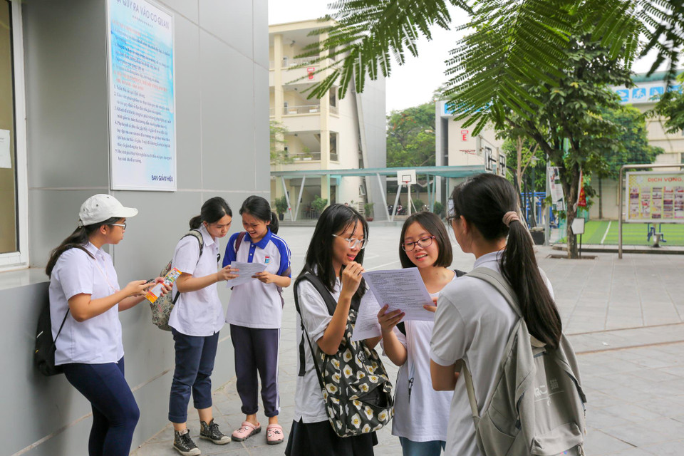 Kết thúc môn thi từ lâu nhưng nhiều thí sinh vẫn nán lại để so đáp án với bạn học. (Ảnh: Minh Sơn/Vietnam+)