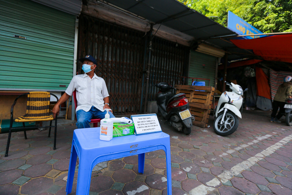 Tại chợ Kim Liên, người dân muốn mua hàng phải tiến hành đo thân nhiệt khử khuẩn mới được vào bên trong. (Ảnh: Minh Sơn/Vietnam+)
