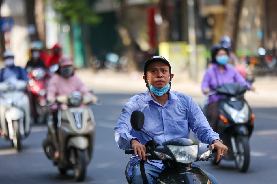 Thậm chí, một số người dân còn không tuân thủ nguyên tắc 5K khi đeo khẩu trang không đúng quy cách khi ra ngoài. (Ảnh: Minh Sơn/Vietnam+)