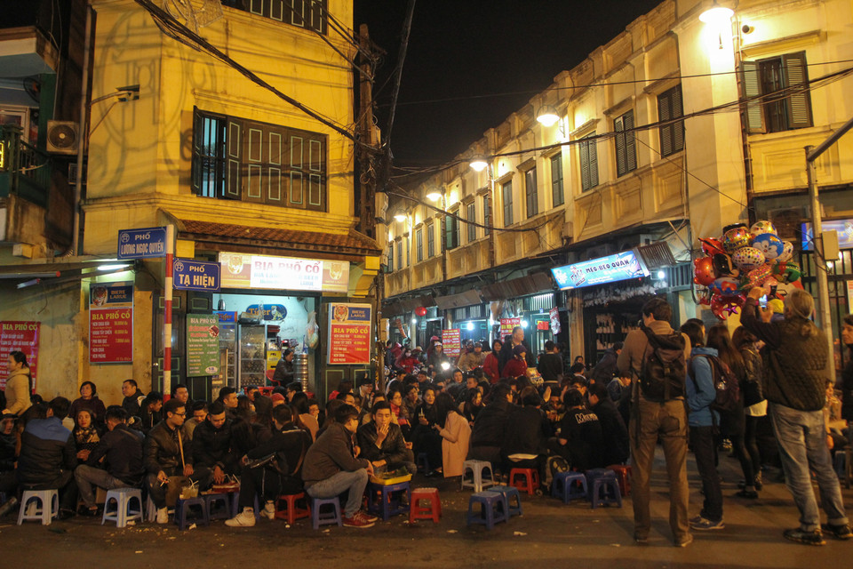 Con phố nhỏ Tạ Hiện được các tín đồ ẩm thực Hà Thành mệnh danh là “Ngã tư quốc tế.” Nhiều khách du lịch nước ngoài đến đây cũng phải trầm trồ vì sự đa dạng của những món quà vặt vừa ngon, vừa rẻ. Thực khách ăn đêm không chỉ giải quyết nhu cầu của cái dạ dày mà còn vì thú vui, gặp gỡ bạn bè chuyện trò sau những giờ làm việc căng thẳng hay dịp để gia đình, người thân quây quần. (Ảnh: Minh Sơn/Vietnam+)