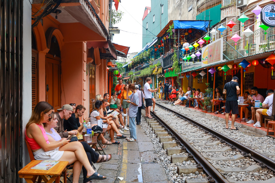 Nhiều khách du lịch tự mách nhau đến Hà Nội nhất định phải ghé qua đây. Họ ngồi nhâm nhi ly càphê hay lai rai vài chai bia và trông ngóng từng chuyến tàu chạy qua. (Ảnh: Minh Sơn/Vietnam+)