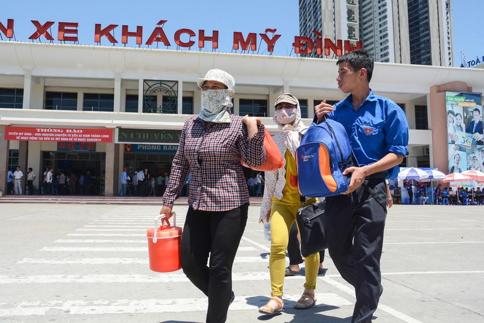 Các tình nguyện viên bê đồ cùng thí sinh ra khỏi khu vực bến xe, năm nay lượng thí sinh đổ về Thủ đô ít hơn hẳn mọi năm nên các sinh viên tình nguyện đỡ vất vả hơn. (Ảnh: Minh Sơn/Vietnam+)