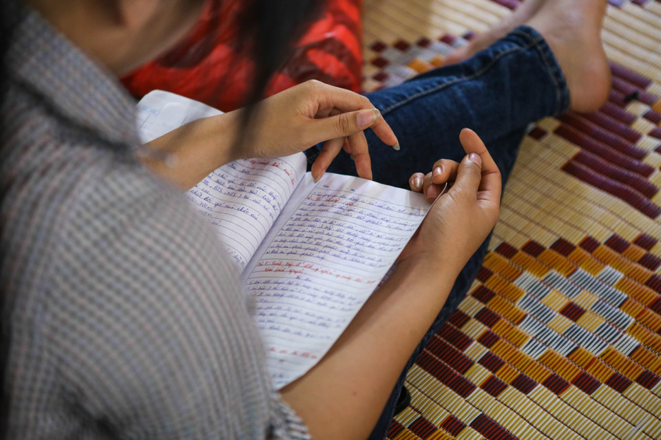 Sĩ tử này tranh thủ mở sách vở ra ôn lại bài trước ngày thi quan trọng nhất trong đời. (Ảnh: Minh Sơn/Vietnam+)