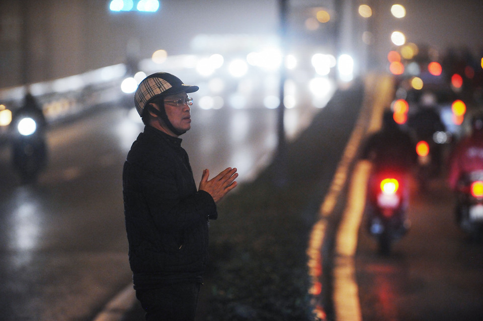 Một vài người dân vì không muốn chen chúc trước cửa chùa nên đã đứng vòng ngoài vái lạy, cầu bình an. (Ảnh: Minh Sơn/Vietnam+)