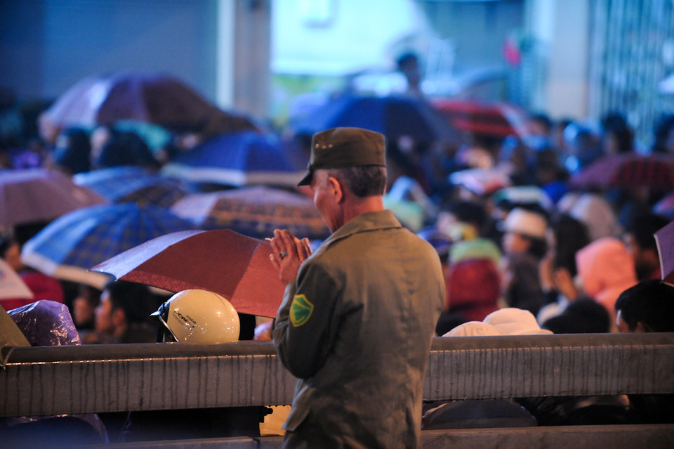 Một bác dân phòng trong lúc tham gia giữ trật tự cũng tranh thủ vái tạ nhà chùa, bác chia sẻ năm nào cũng phải vào chùa thắp hương, xin lộc. (Ảnh: Minh Sơn/Vietnam+)