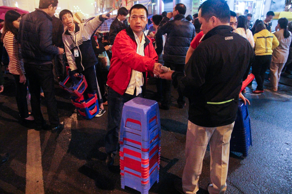 Nhiều dân sống quanh chùa đã tận dụng cơ hội cho thuê ghế mới mức giá 10 ngàn đồng/chiếc để người đến cúng có thể ngồi trong lúc hành lễ. (Ảnh: Minh Sơn/Vietnam+)