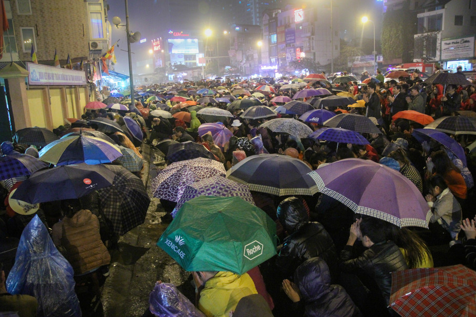 19 giờ, chùa bắt đầu làm lễ nhưng từ 18 giờ tối, người dân đã tập trung đông nghẹt trước cổng chùa. Lực lượng chức năng phải phân luồng các phương tiện đi lên cầu vượt Ngã Tư Sở. (Ảnh: Minh Sơn/Vietnam+)