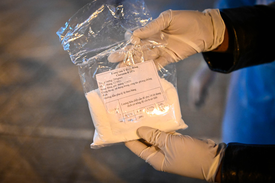 Mỗi gói Cloramin B khối lượng 200gr được pha với 10 lít nước sạch sau đó sử dụng máy phun phòng chống dịch vác vai và phun dưới dạng sương mịn. (Ảnh: Minh Sơn/Vietnam+)