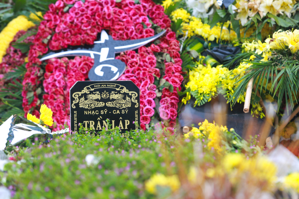 Nằm cách đó không xa, nơi nhạc sỹ Trần Lập yên nghỉ, những ngày này đông hơn thường lệ, những lẵng hoa tươi phủ đầy trên trên phần mộ của anh. (Ảnh: My Nguyễn/Vietnam+)