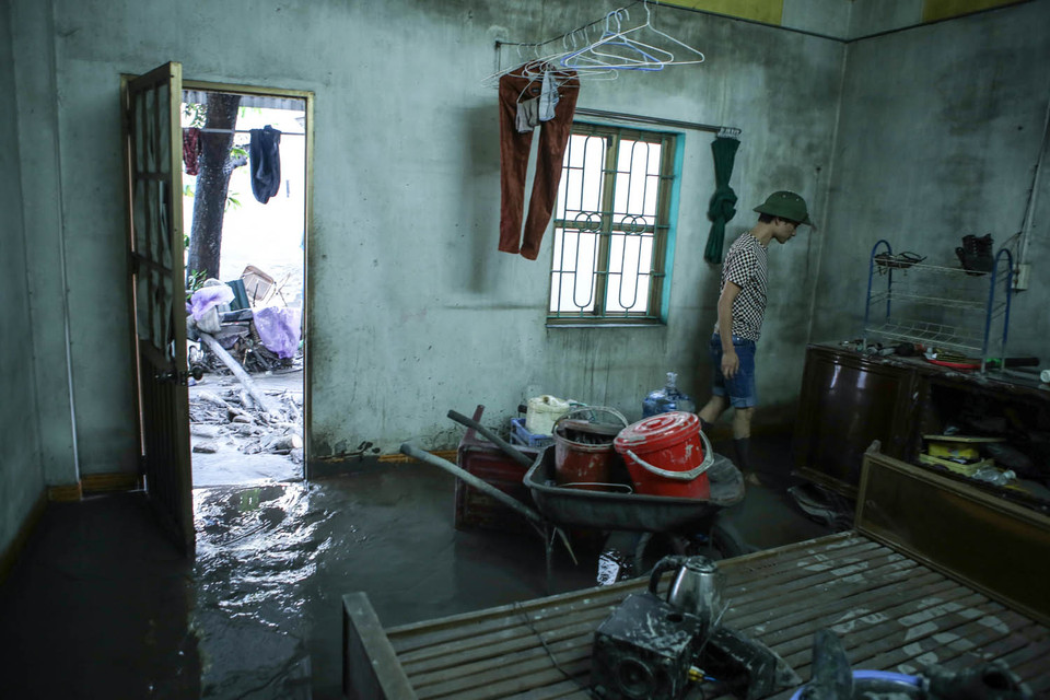 Người dân cố gắng tìm kiếm những đồ đạc còn sót lại trong căn nhà. (Ảnh: PV/Vietnam+)